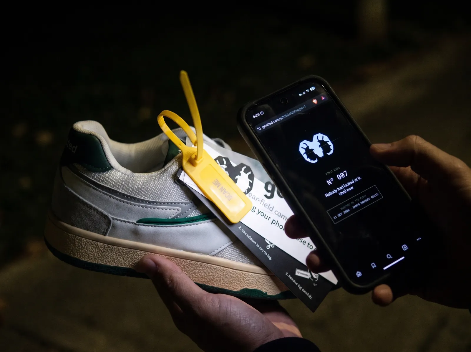 Un tenis goatted de noche junto a un teléfono encendido